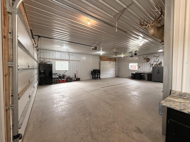 2771 271st Ave, Madison, MN 56256 - garage with a garage door opener and black fridge