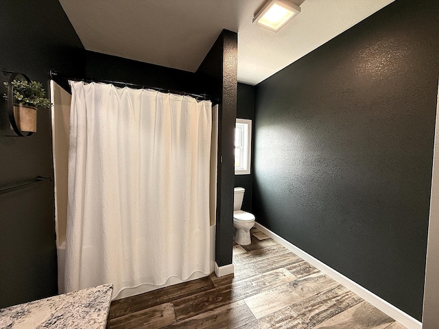 2771 271st Ave, Madison, MN 56256 - bathroom with toilet, wood finished floors, curtained shower, and baseboards