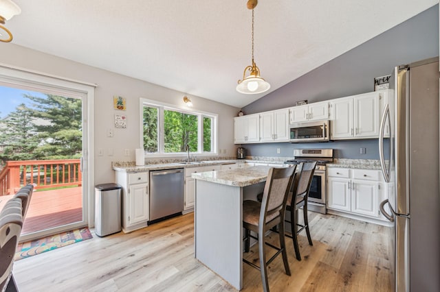10344 Fox Run Rd, Woodbury, MN 55129 - kitchen with stainless steel appliances, white cabinetry, a center island, light wood-style flooring, and lofted ceiling