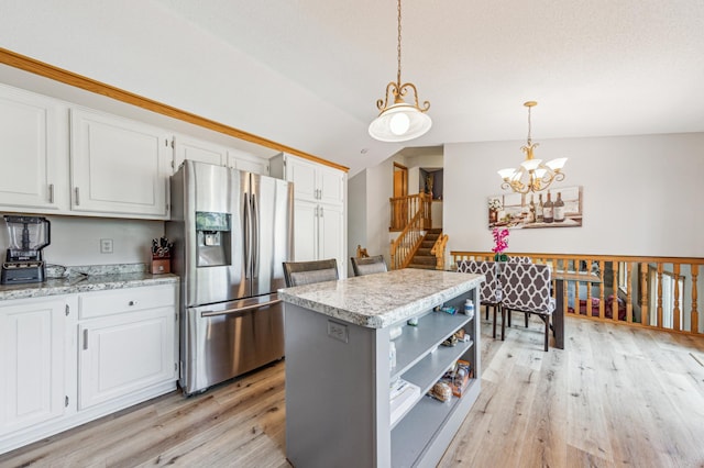 10344 Fox Run Rd, Woodbury, MN 55129 - kitchen featuring stainless steel fridge, light wood finished floors, white cabinetry, a center island, and decorative light fixtures