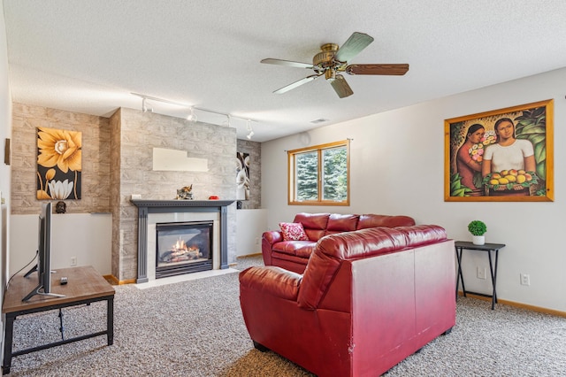 10344 Fox Run Rd, Woodbury, MN 55129 - carpeted living area with rail lighting, ceiling fan, a textured ceiling, a glass covered fireplace, and baseboards