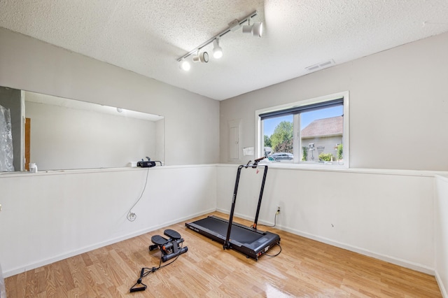 10344 Fox Run Rd, Woodbury, MN 55129 - workout area with wood finished floors, a textured ceiling, and rail lighting