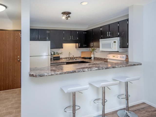 4010 52nd St Unit 204, Minneapolis, MN 55417 - kitchen with white appliances, a sink, dark cabinets, and backsplash