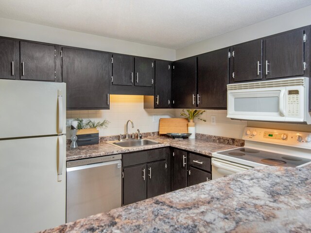 4010 52nd St Unit 204, Minneapolis, MN 55417 - kitchen featuring white appliances, a sink, decorative backsplash, and dark cabinetry