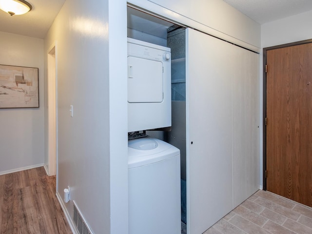 4010 52nd St Unit 204, Minneapolis, MN 55417 - washroom featuring stacked washing machine and dryer and light wood-style flooring