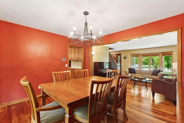 5921 Creek Pt, Minnetonka, MN 55345 - dining room featuring light wood-style flooring, a chandelier, stairs, and baseboards