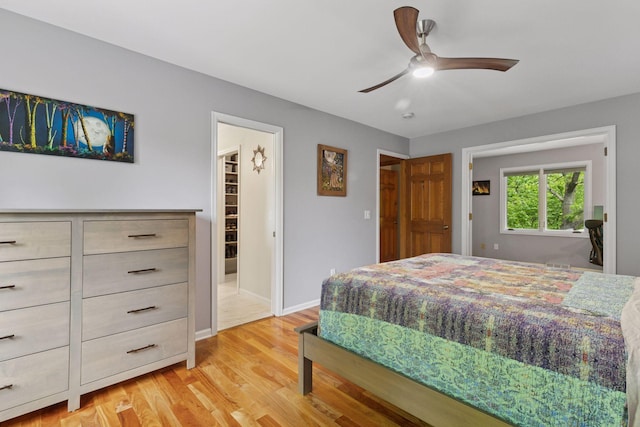 5921 Creek Pt, Minnetonka, MN 55345 - bedroom with light wood finished floors, baseboards, a spacious closet, and ceiling fan