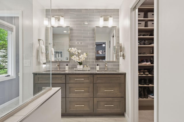 5921 Creek Pt, Minnetonka, MN 55345 - bathroom featuring double vanity, a spacious closet, tasteful backsplash, baseboards, and a shower