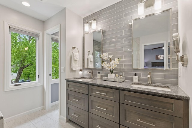 5921 Creek Pt, Minnetonka, MN 55345 - full bathroom featuring double vanity, baseboards, marble finish flooring, and tasteful backsplash