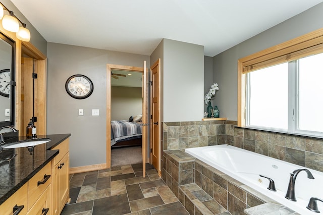 2292 Teakwood Ln SW, Rochester, MN 55902 - ensuite bathroom featuring vanity, a tub with jets, stone finish floors, and baseboards
