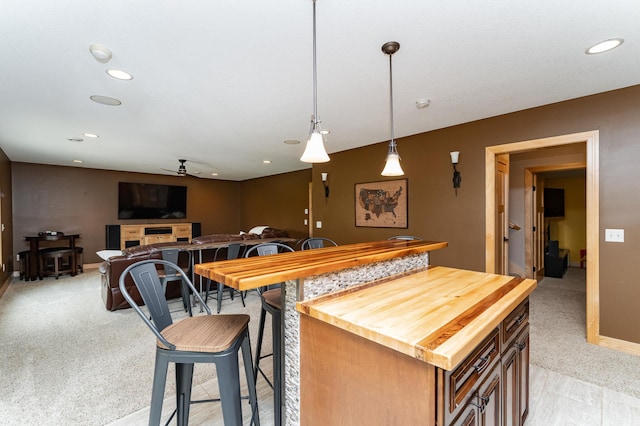 2292 Teakwood Ln SW, Rochester, MN 55902 - kitchen with light carpet, ceiling fan, recessed lighting, wooden counters, and decorative light fixtures