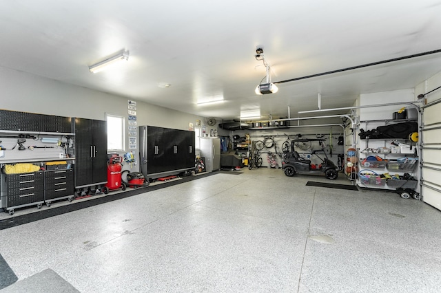 2292 Teakwood Ln SW, Rochester, MN 55902 - garage with a workshop area, a garage door opener, and freestanding refrigerator