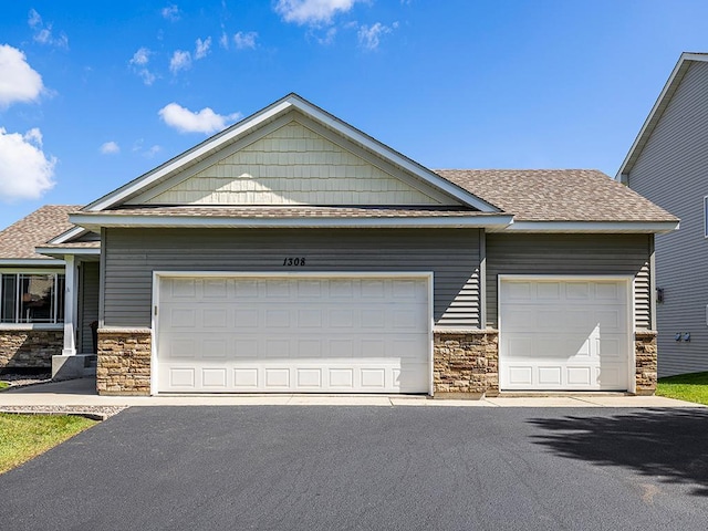 1308 Timber Ln, Buffalo, MN 55313 - view of front of home featuring stone siding, roof with shingles, and driveway