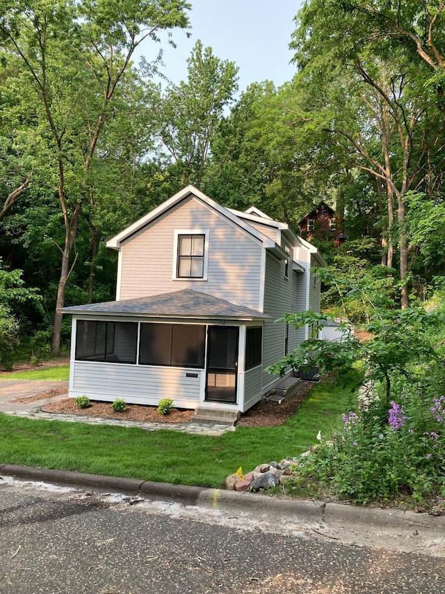 112 Harriet St S, Stillwater, MN 55082 - view of front of property featuring a sunroom, a front lawn, and roof with shingles