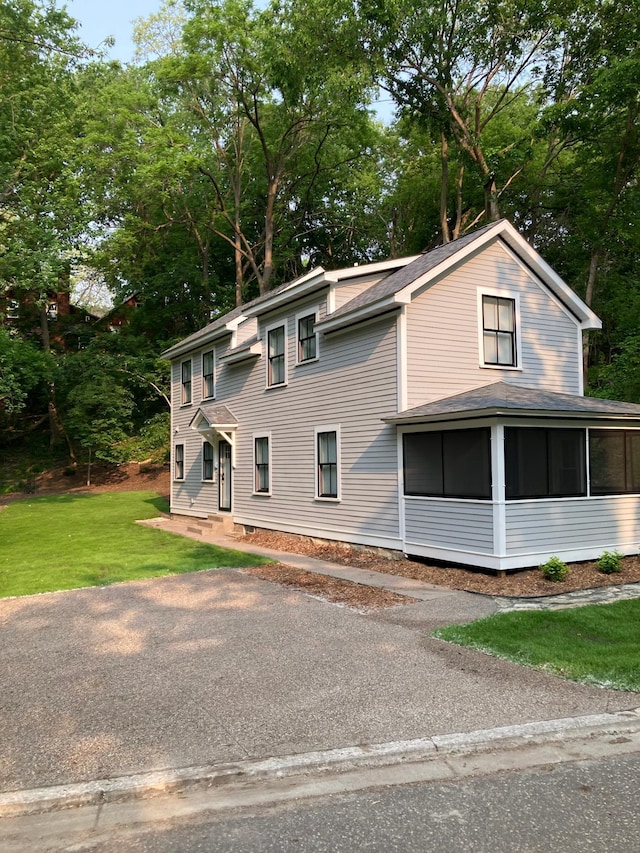 112 Harriet St S, Stillwater, MN 55082 - view of front facade featuring a sunroom, a front yard, and view of wooded area