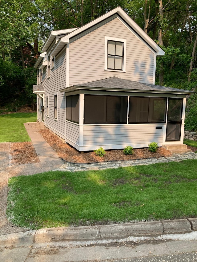 112 Harriet St S, Stillwater, MN 55082 - view of property exterior featuring a sunroom, a lawn, and a shingled roof