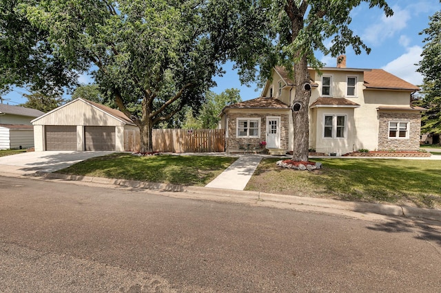 607 23rd Ave N, Saint Cloud, MN 56303 - view of front of home featuring stucco siding, stone siding, a detached garage, an outbuilding, and a chimney