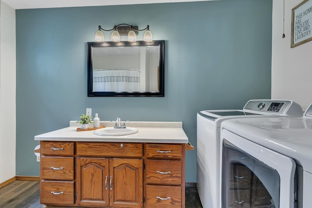607 23rd Ave N, Saint Cloud, MN 56303 - bathroom with washing machine and dryer, vanity, wood finished floors, and baseboards