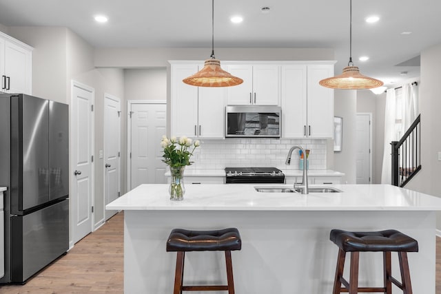 5322 94th Ln N, Brooklyn Park, MN 55443 - kitchen with stainless steel appliances, a sink, light wood-style flooring, decorative backsplash, and recessed lighting