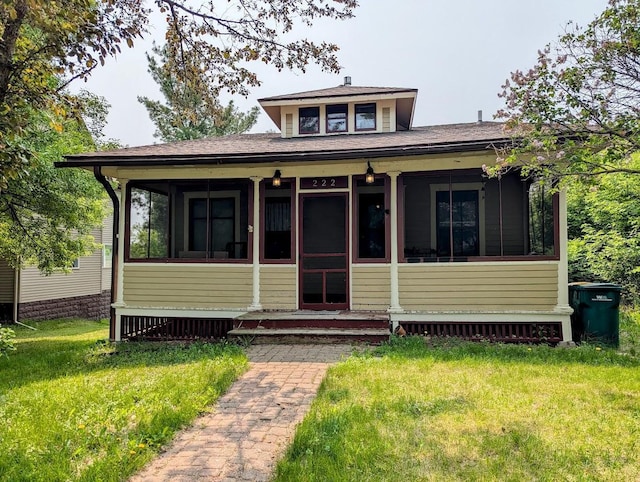 222 Ione Ave NE, Hill City, MN 55748 - view of front of home with a sunroom, a front lawn, and roof with shingles