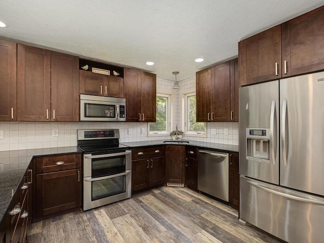 15564 Vale St NW, Andover, MN 55304 - kitchen with stainless steel appliances, wood finished floors, backsplash, a sink, and recessed lighting