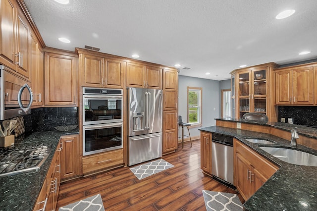 631 Bench St, Taylors Falls, MN 55084 - kitchen featuring stainless steel appliances, a sink, dark wood-style floors, brown cabinets, and a textured ceiling