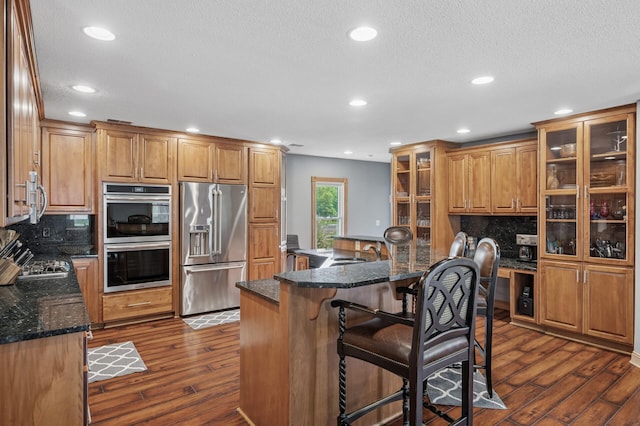 631 Bench St, Taylors Falls, MN 55084 - kitchen with stainless steel appliances, tasteful backsplash, dark wood-type flooring, a sink, and a textured ceiling