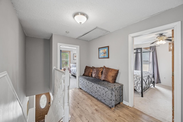 631 Bench St, Taylors Falls, MN 55084 - sitting room with an upstairs landing, attic access, light wood-style floors, a textured ceiling, and a ceiling fan