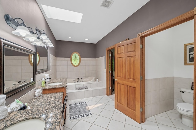 631 Bench St, Taylors Falls, MN 55084 - full bathroom with vanity, a bath, toilet, a skylight, and tile patterned flooring