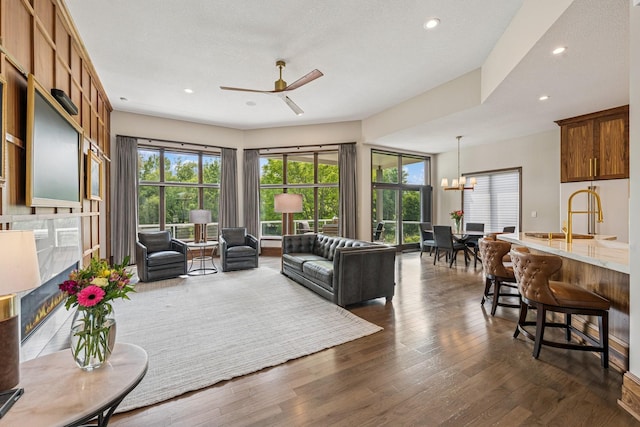 11883 Flanders Cir NE, Blaine, MN 55449 - living area with ceiling fan, recessed lighting, dark wood-style floors, and a chandelier