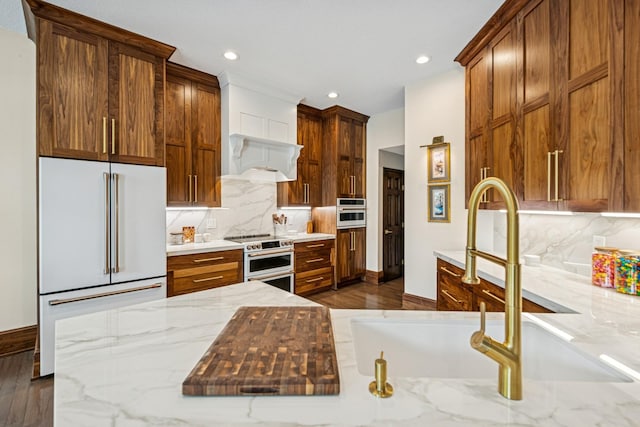 11883 Flanders Cir NE, Blaine, MN 55449 - kitchen featuring stove, high end white fridge, decorative backsplash, recessed lighting, and light stone countertops