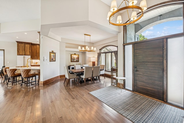 11883 Flanders Cir NE, Blaine, MN 55449 - foyer entrance with a chandelier, light wood-style floors, and a towering ceiling