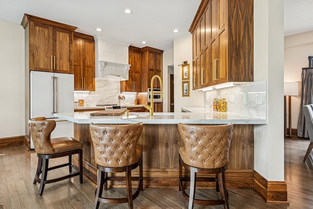 11883 Flanders Cir NE, Blaine, MN 55449 - kitchen with dark wood-type flooring, decorative backsplash, light countertops, a peninsula, and high end fridge
