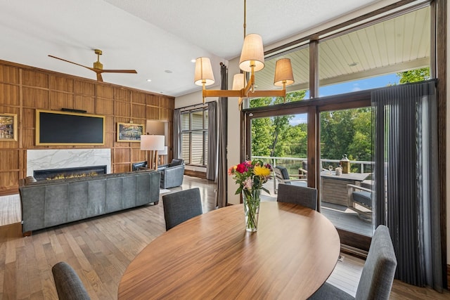 11883 Flanders Cir NE, Blaine, MN 55449 - dining room featuring healthy amount of natural light, hardwood / wood-style flooring, wooden walls, and a ceiling fan