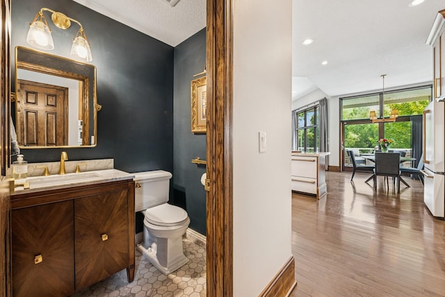 11883 Flanders Cir NE, Blaine, MN 55449 - bathroom with vanity, wood finished floors, recessed lighting, and lofted ceiling
