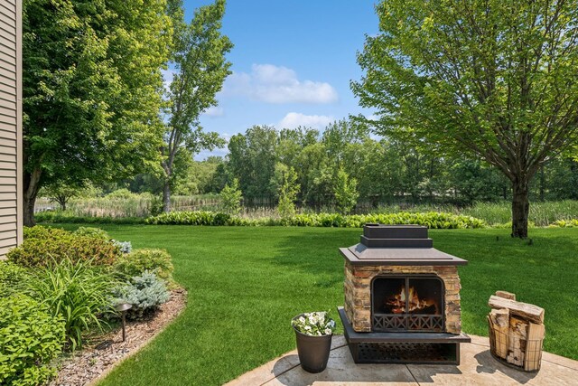 11883 Flanders Cir NE, Blaine, MN 55449 - view of green lawn with an outdoor stone fireplace and view of scattered trees