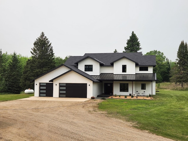 26575 US-71, Arago Twp, MN 56470 - modern farmhouse featuring a standing seam roof, concrete driveway, a front lawn, a porch, and metal roof