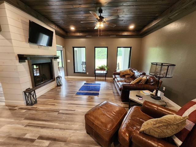 26575 US-71, Arago Twp, MN 56470 - living room featuring wood ceiling, wood finished floors, a fireplace, baseboards, and ceiling fan