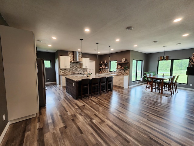 26575 US-71, Arago Twp, MN 56470 - kitchen with wall chimney exhaust hood, recessed lighting, freestanding refrigerator, backsplash, and dark wood finished floors