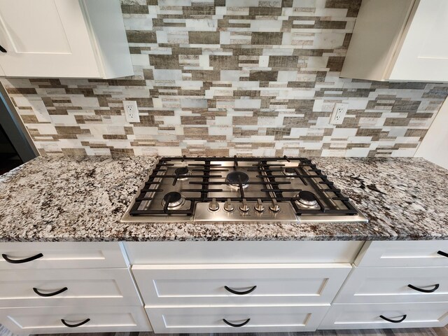 26575 US-71, Arago Twp, MN 56470 - kitchen view of stainless steel gas cooktop, white cabinets, tasteful backsplash, and stone counters