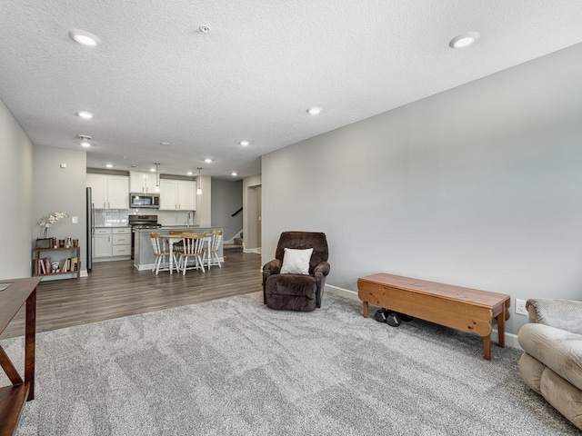 1211 Lower 143rd St E, Rosemount, MN 55068 - sitting room featuring recessed lighting, dark wood-type flooring, baseboards, stairs, and a textured ceiling