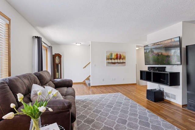 2517 Cobble Hill Ct Unit I, Woodbury, MN 55125 - living room with a textured ceiling, stairway, wood finished floors, and baseboards