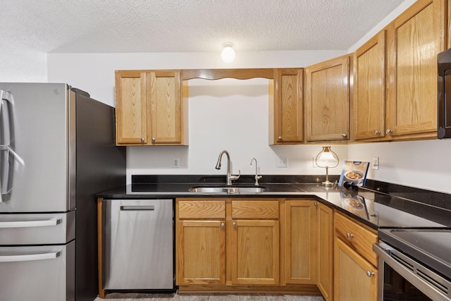 2517 Cobble Hill Ct Unit I, Woodbury, MN 55125 - kitchen with stainless steel appliances, a sink, dark countertops, and a textured ceiling