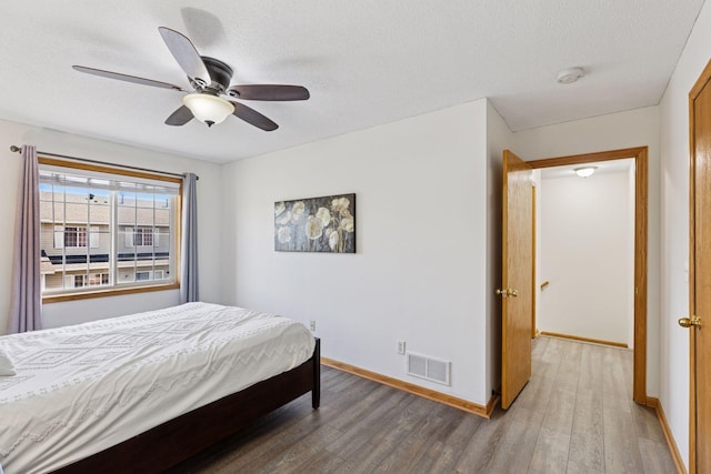 2517 Cobble Hill Ct Unit I, Woodbury, MN 55125 - bedroom with wood finished floors, baseboards, a textured ceiling, and ceiling fan