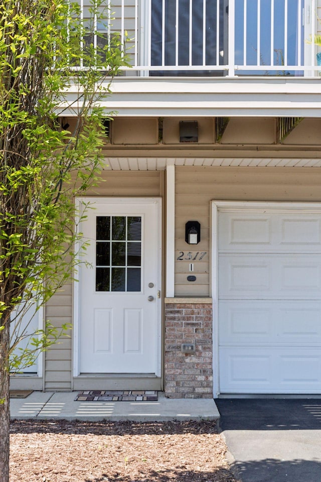 2517 Cobble Hill Ct Unit I, Woodbury, MN 55125 - view of exterior entry featuring brick siding and a garage