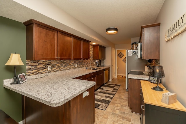 201 Chandler Ct, Jordan, MN 55352 - kitchen with decorative backsplash, a sink, stainless steel dishwasher, a peninsula, and stone finish flooring