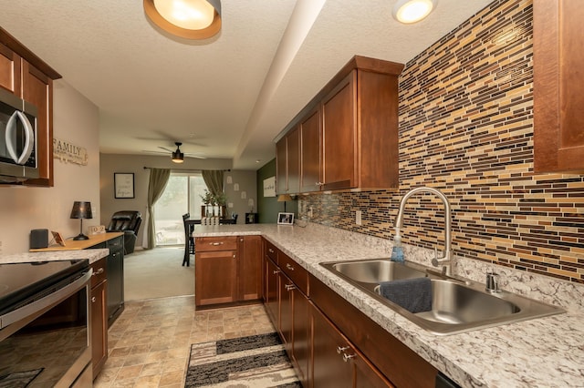 201 Chandler Ct, Jordan, MN 55352 - kitchen featuring a sink, stainless steel appliances, backsplash, light countertops, and a textured ceiling