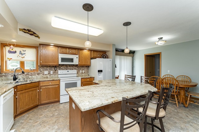 1218 6th St NW, Dodge Center, MN 55927 - kitchen featuring white appliances, a breakfast bar area, a sink, and brown cabinetry