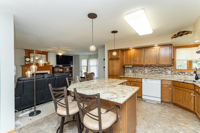 1218 6th St NW, Dodge Center, MN 55927 - kitchen with dishwasher, a sink, brown cabinets, and a breakfast bar