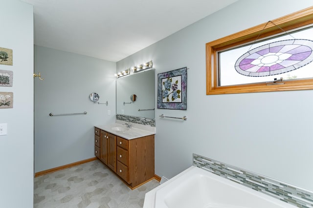 1218 6th St NW, Dodge Center, MN 55927 - bathroom featuring vanity, a garden tub, baseboards, and tile patterned floors